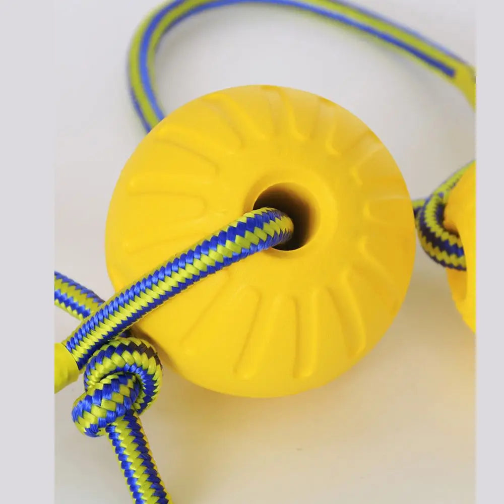 A yellow rubber fetch ball with a blue and yellow braided rope attached, shown against a white background.