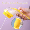 A hand is pressing a button on a silicone pet bath brush with a yellow dispenser to release liquid.