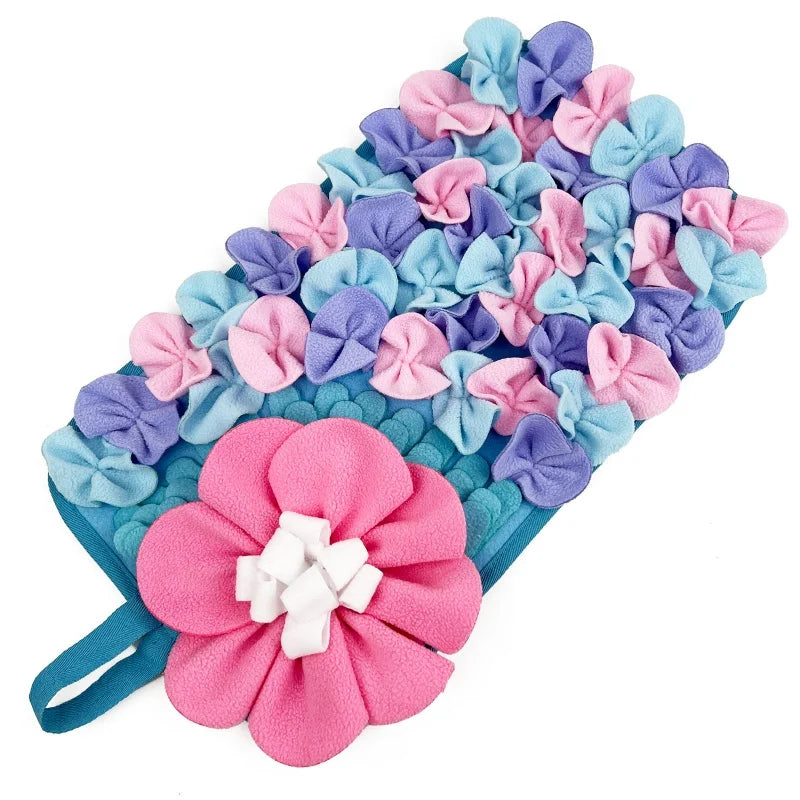 A colorful mat with pink and blue flowers used for interactive pet foraging.