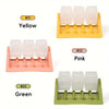 Three colored silicone puzzle feeders labeled Yellow, Pink, and Green displayed in individual yellow, pink, and green trays.