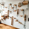 Wall-mounted cat climbing shelves featuring a hammock and scratching post mounted on a white wall.