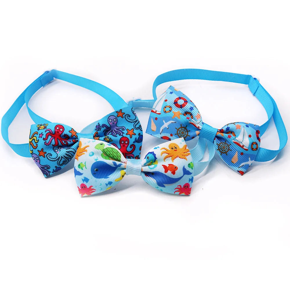 Ein Set von zehn dekorativen Hundebows mit bunten Fischen und Meerestieren auf blauem Stoff.
