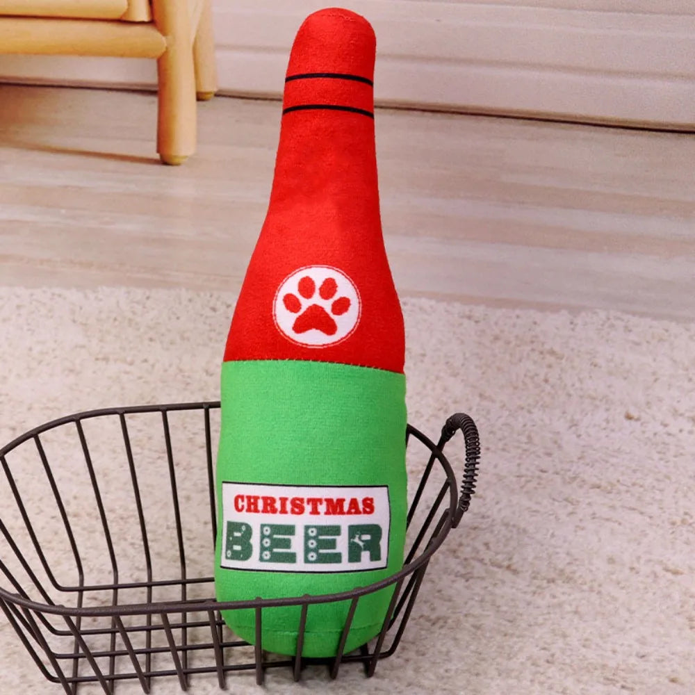 A red and green bottle-shaped plush dog toy with a paw print design is placed in a wire basket.