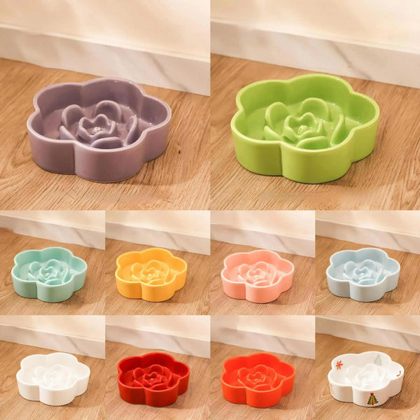A collection of ceramic slow feeder cat bowls in various pastel colors and shapes displayed on a wooden surface.