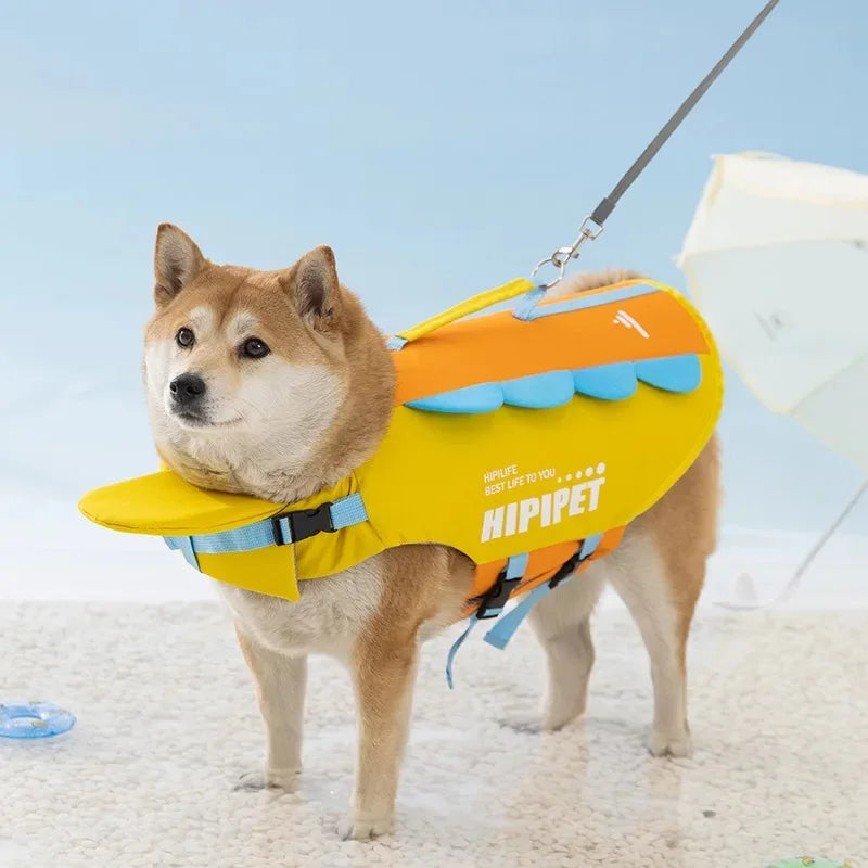 Un perro marrón claro vistiendo un chaleco salvavidas amarillo y naranja para nadar en verano.