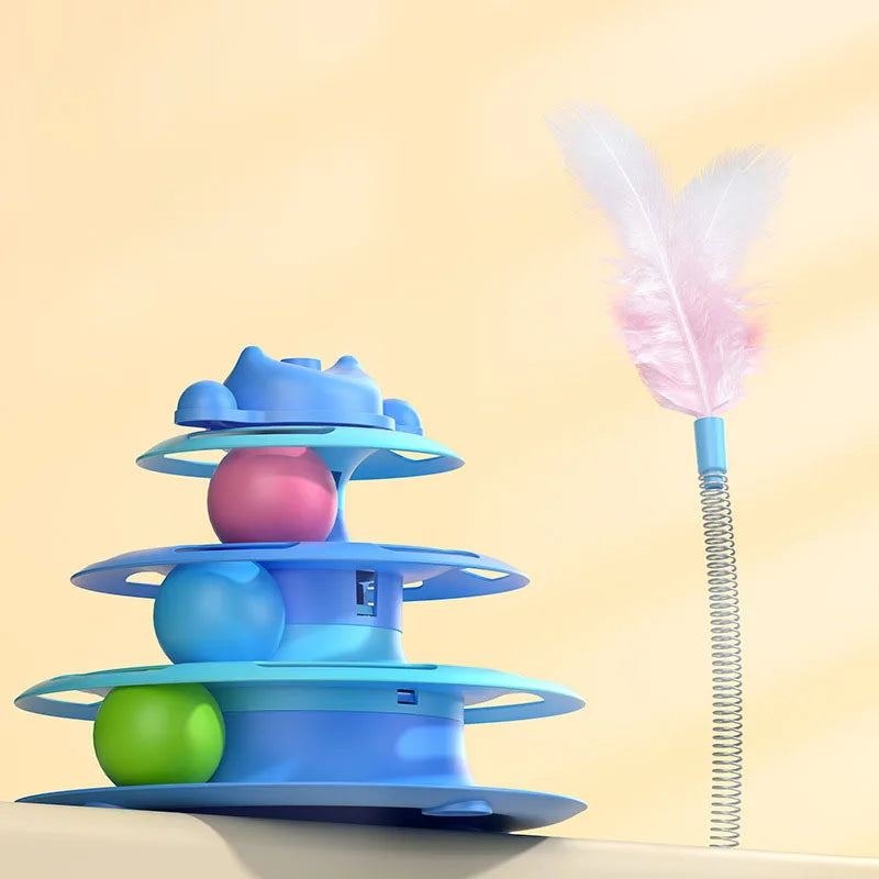 A blue interactive cat turntable toy with rolling balls and a pink feather wand on a light background.