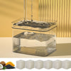 A clear glass water fountain with an activated carbon replacement filter assembly and several blocks of white activated carbo