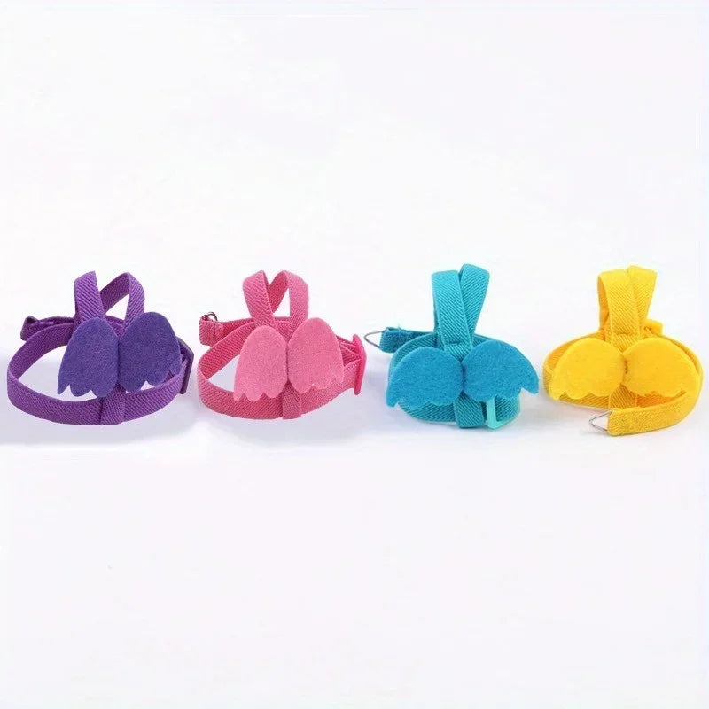 A set of four colorful parrot bird harnesses and leashes in purple, pink, teal, and yellow.