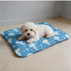 A fluffy white puppy is lying on a blue pet mat decorated with white jellyfish patterns.