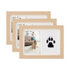 A set of three light wood frames displaying a black dog paw print design on white backgrounds.