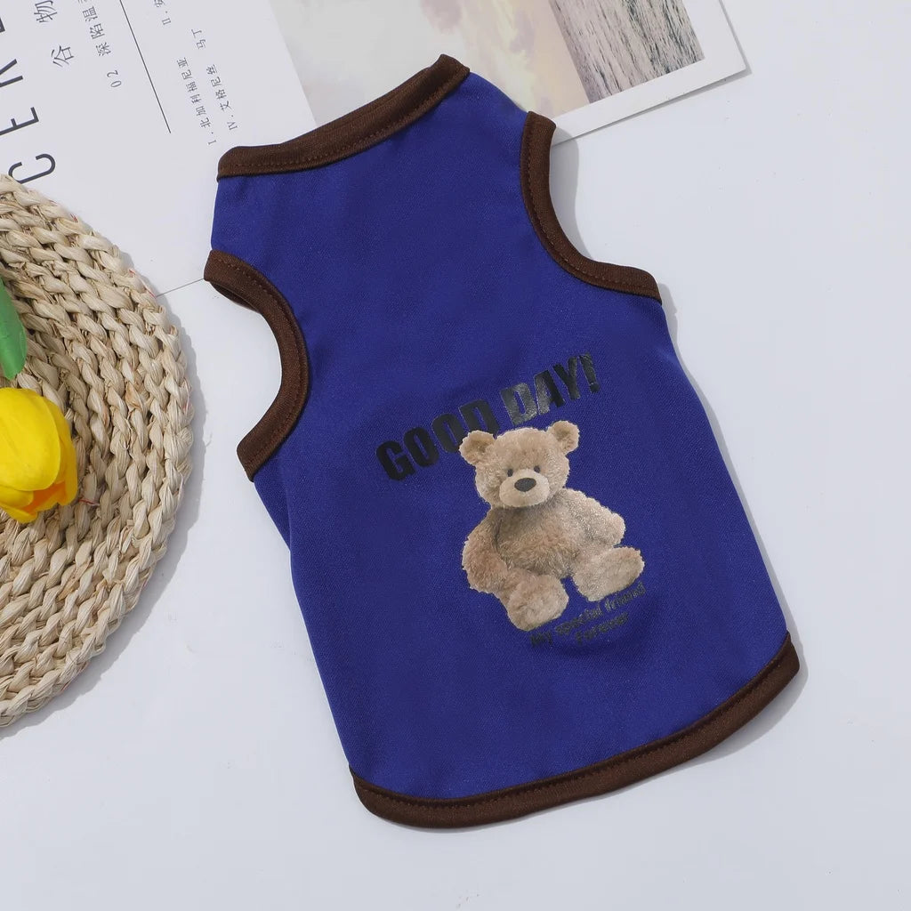 A royal blue pet vest featuring a cartoon teddy bear design with the text GOOD DAY!