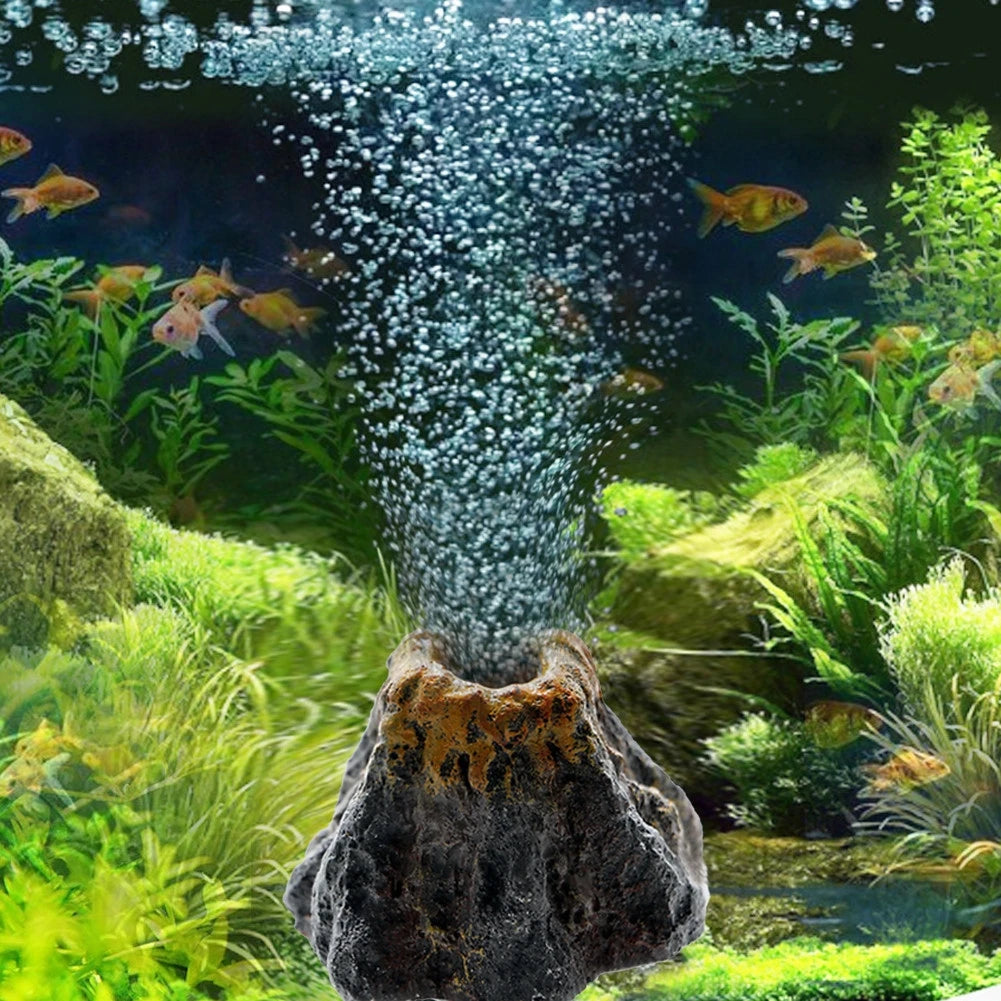 Aquarium volcano decoration featuring a stone structure with bubbling water and aquatic plants.