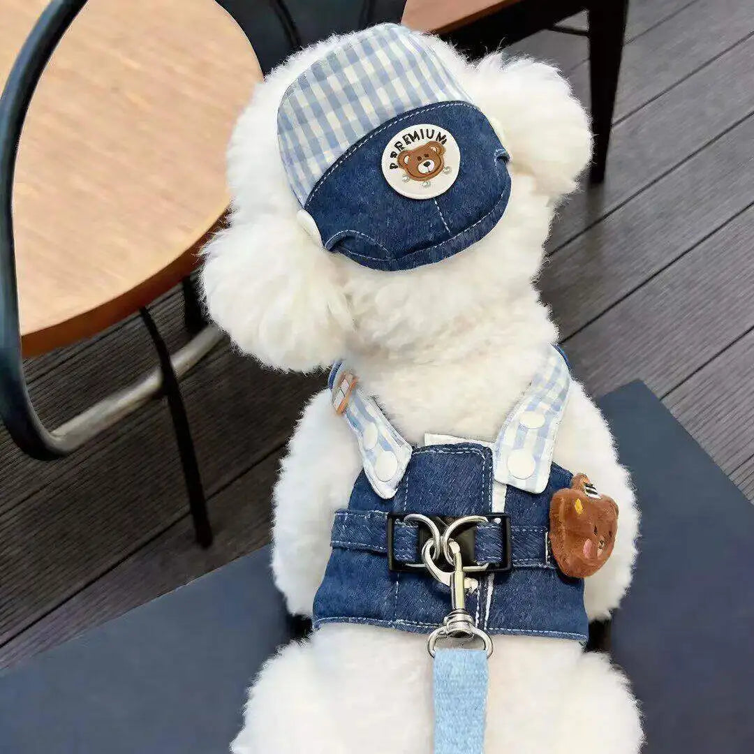 A fluffy white cartoon dog plush wearing a blue and white plaid harness vest with a leather tag and chain.