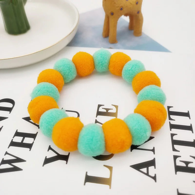A colorful pet collar and bow tie set featuring bright orange and light blue fuzzy fabric.