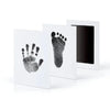 A set of baby handprint and footprint kits displayed in white frames.