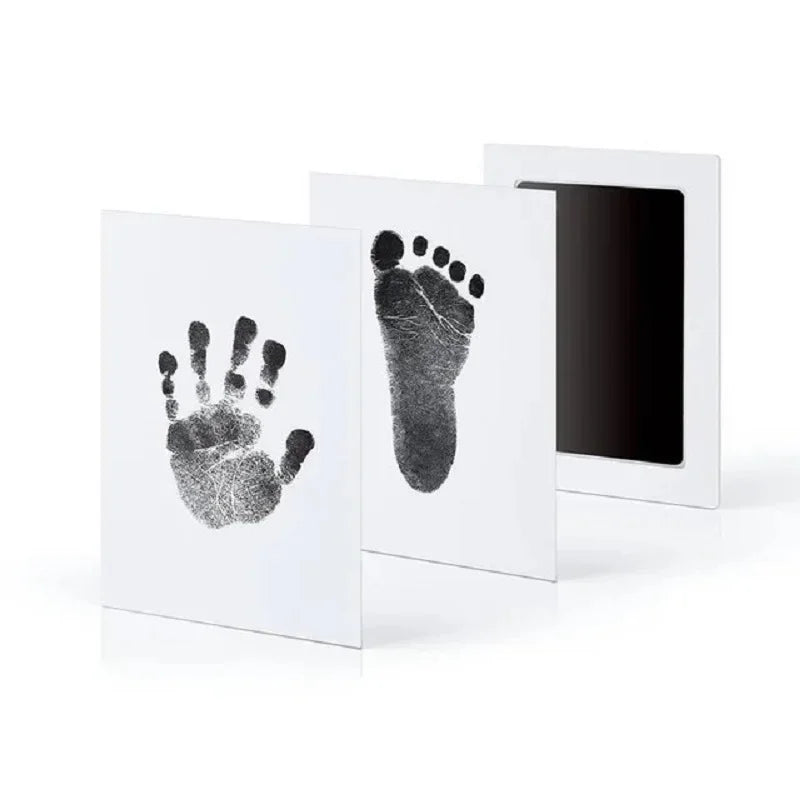 A set of baby handprint and footprint kits displayed in white frames.