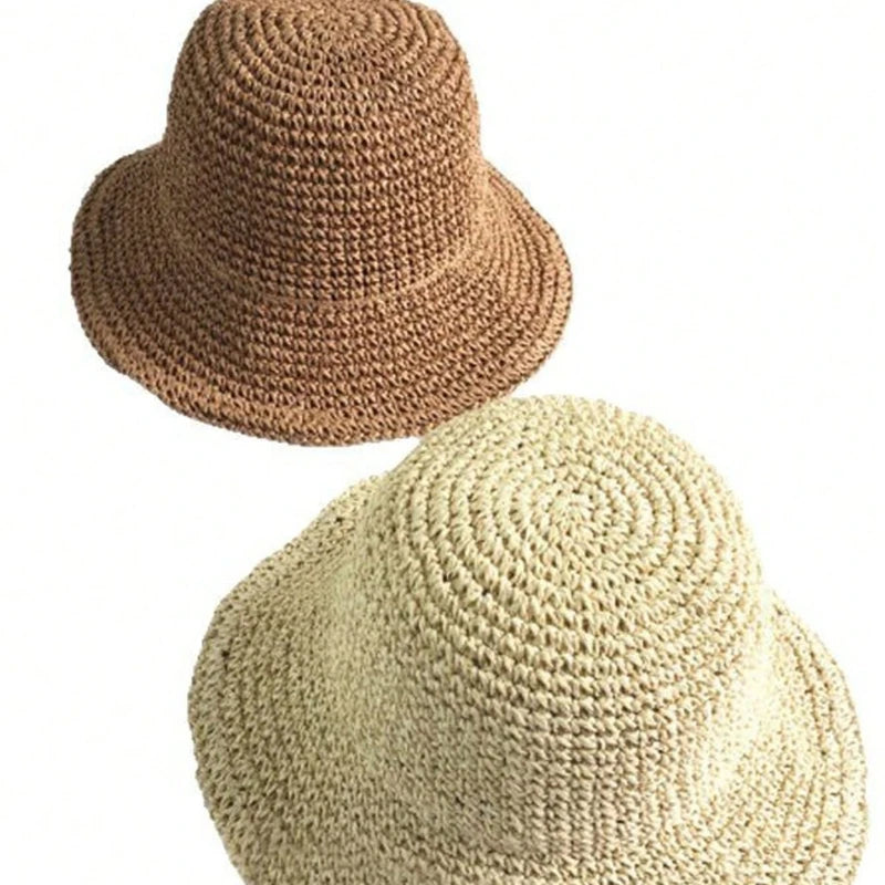 Gros plan sur deux chapeaux en paille tissés, un marron et un beige, montrant la texture et l'artisanat.
