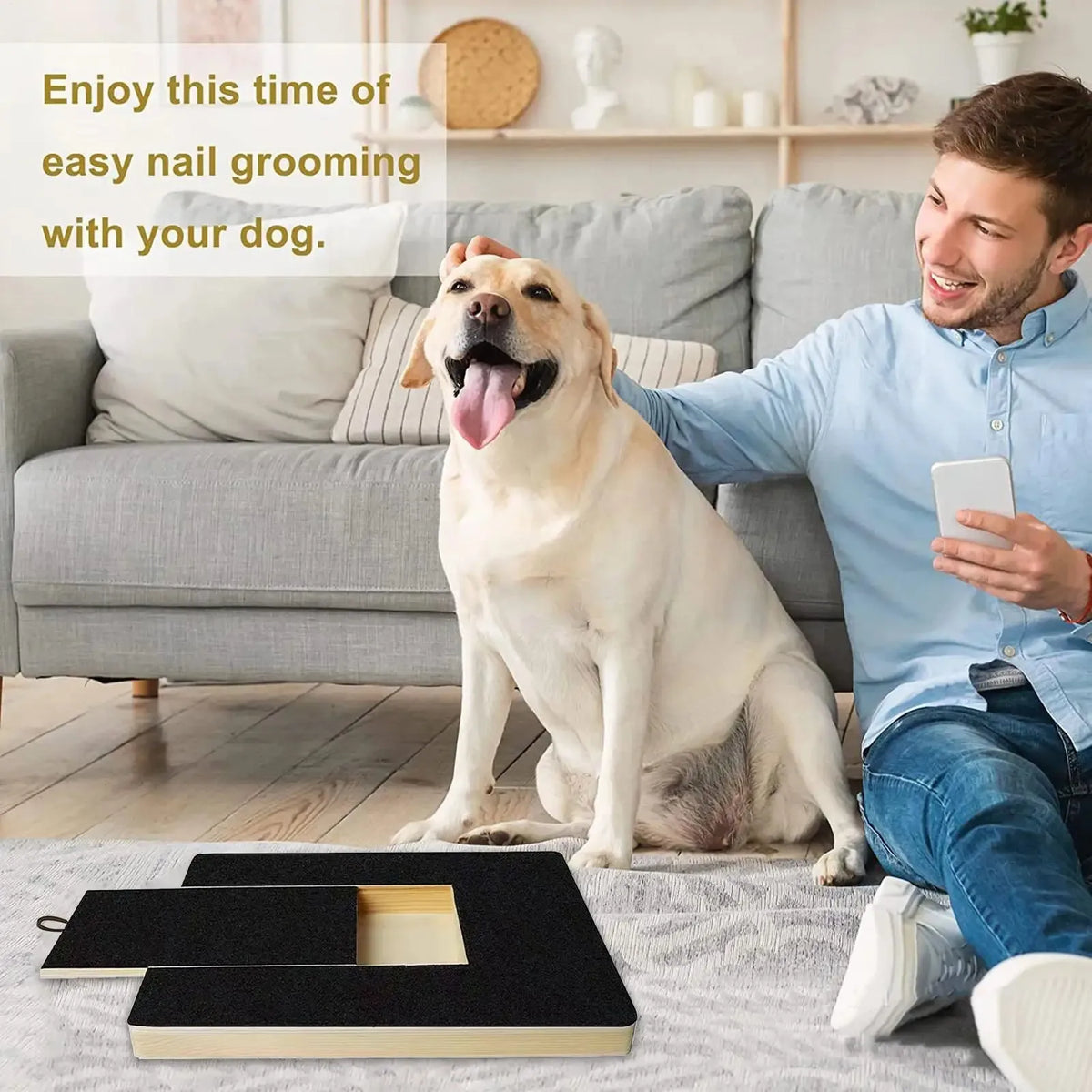 A man is grooming a Golden Retriever dog on a couch with a wooden nail scratching board and treat box.