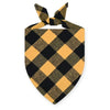 A black and gold plaid bandana tied in a bow for a dog