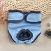 Light blue reusable dog diapers with dark gray trim resting on a woven mat.