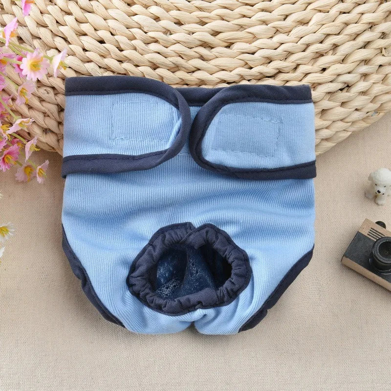 Light blue reusable dog diapers with dark gray trim resting on a woven mat.