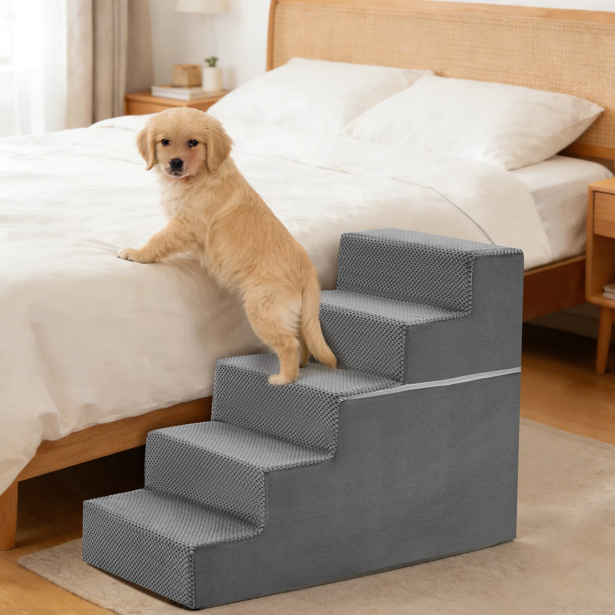A golden retriever dog is standing on a gray adjustable pet climbing stairs ramp next to a wooden bed.