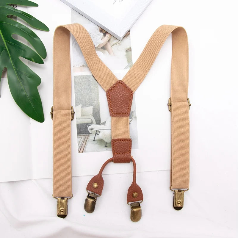 A pair of tan adjustable clip-on suspenders for kids displayed on a white background.