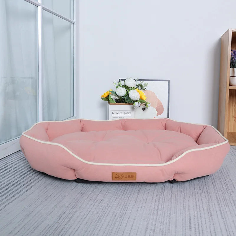 A pink corduroy pet sofa bed for dogs and cats resting on a light gray floor.
