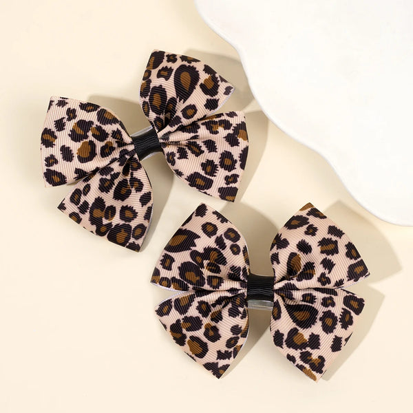 Ein Paar Leopardenmuster-Haarspangen in beige- und braunen Tönen.