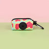 A colorful, patterned pouch designed to hold dog poop, featuring pink and blue designs.