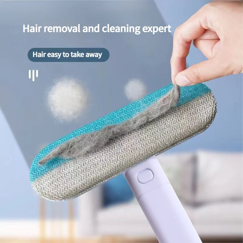 A hand is using a pet hair remover brush with a blue and gray head to remove hair from a surface.