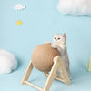 A fluffy gray kitten is interacting with a round sisal rope ball toy supported by a wooden base against a light blue backgrou
