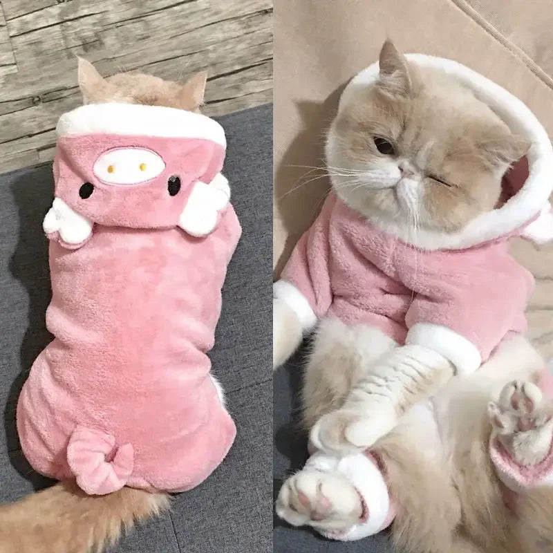 A fluffy ginger cat wearing a pink fleece jumpsuit and hood.