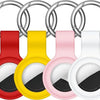 A set of silver silicone airtag protective covers with keychains in red, yellow, and pink.