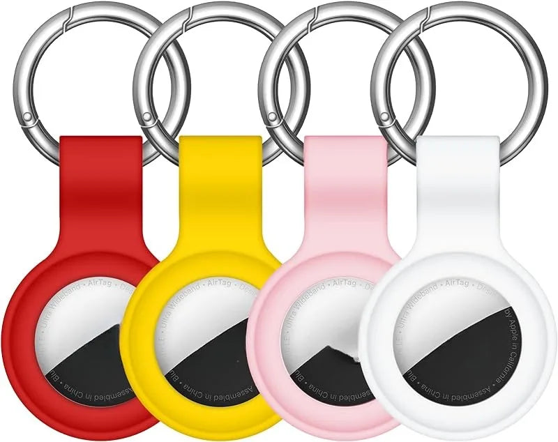 A set of silver silicone airtag protective covers with keychains in red, yellow, and pink.