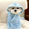 A white dog wearing a light blue absorbent quick-dry bathrobe with a hood.