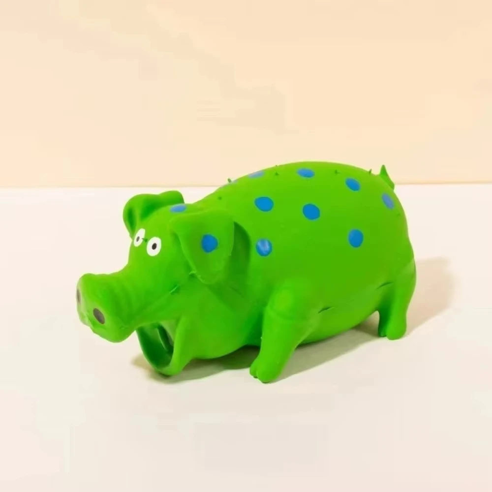 A bright green plastic pig squeaky toy with blue polka dots lying on a white surface.