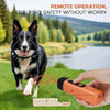 A hand holds an orange ultrasonic dog bark deterrent training device with a dog in a grassy outdoor setting.