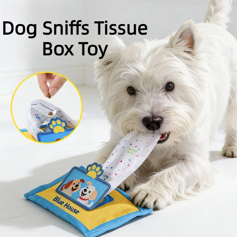 A white dog is sniffing a blue tissue box toy for dogs with a squeaker.