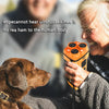 A woman holds an orange ultrasonic dog bark control device while looking at a brown dog.