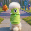 A fluffy white dog wearing a bright green seasonal flannel hoodie with large eyes standing outdoors.