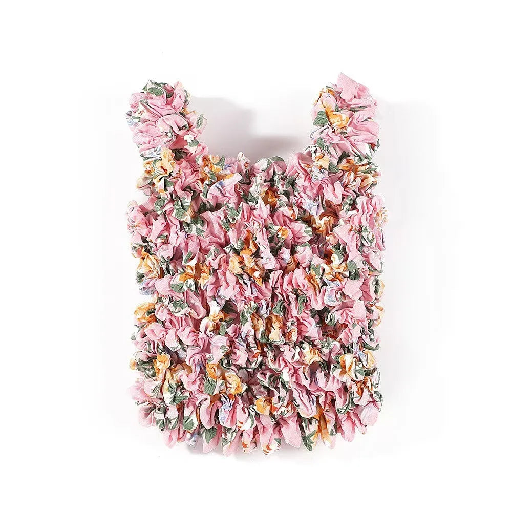 A reusable foldable bubble shopping bag made of pink and yellow floral fabric.