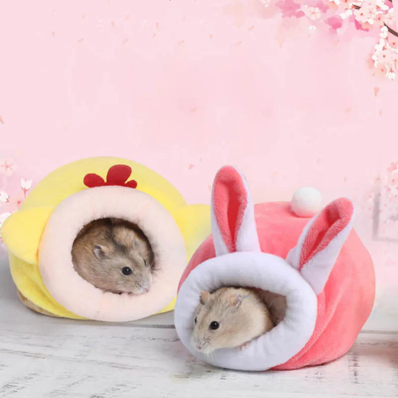 A plush hamster sleeping nest made of soft pink and yellow fabric with ears and a round opening.