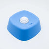 A bright blue silicone lick bowl with a white textured disc on top.