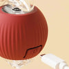 A terracotta-colored interactive rechargeable cat toy ball with a clear silicone component and a white connector.