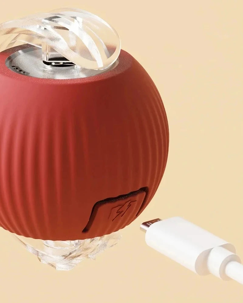 A terracotta-colored interactive rechargeable cat toy ball with a clear silicone component and a white connector.
