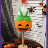 Disfraces de calabaza naranja tallada exhibido en maniquí, decorado con acentos puntiagudos de Halloween.