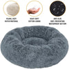 A round, gray, fluffy pet bed with a thick, soft outer material and a waterproof bottom.