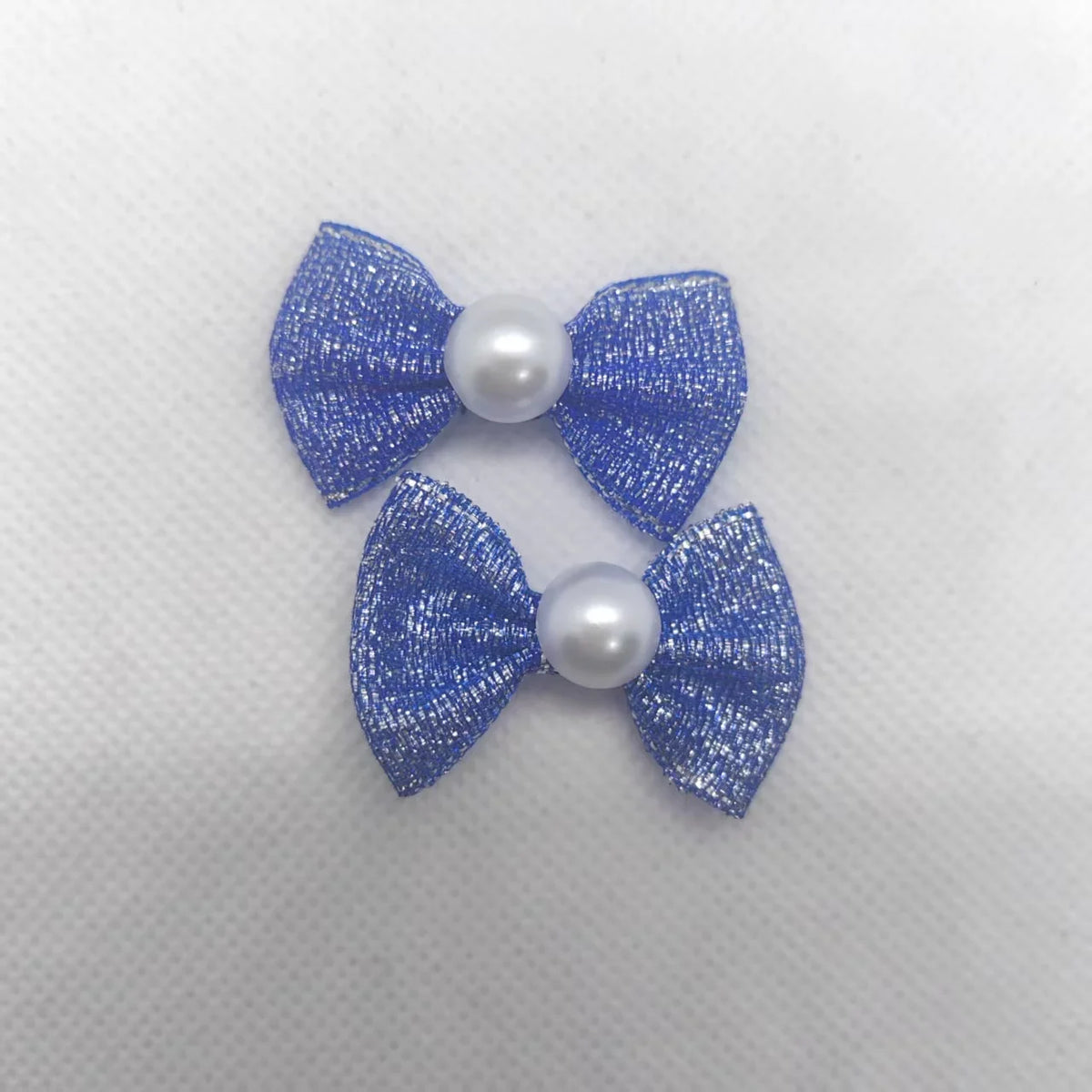 Ein Set aus drei glitzernden blauen Hundebändeln mit Perlmitten für das Tierpflegegrooming.