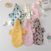 A collection of cartoon printed dog raincoats in various colors and patterns displayed on a white surface.